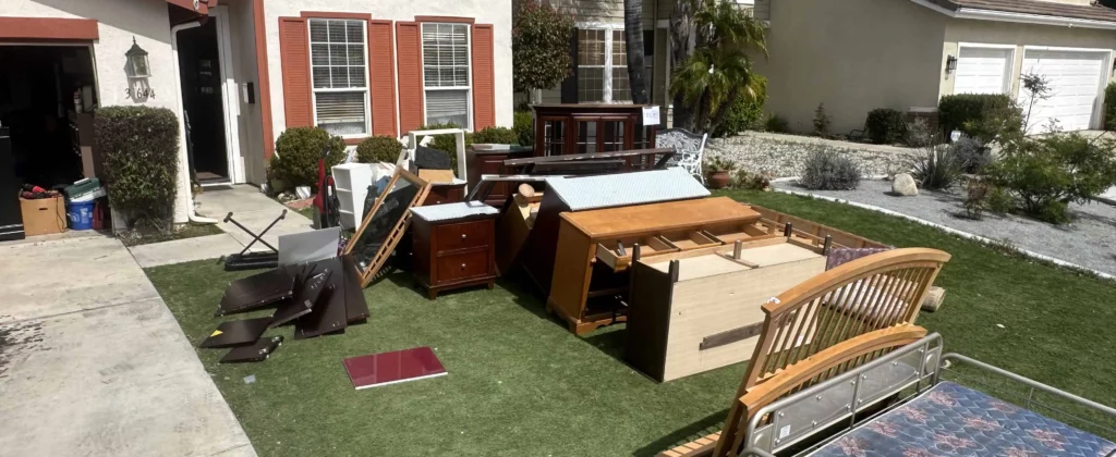 Household junk and furniture staged on lawn for removal service