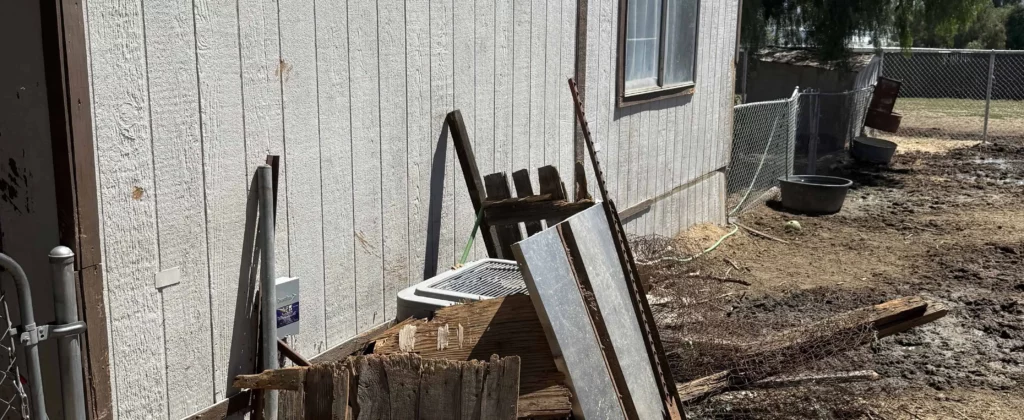 Yard debris and scrap piled beside shed for junk removal